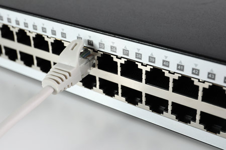 Closeup view of network switch with cable on light background. internet connection