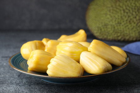 Fresh exotic jackfruit bulbs on gray tableの写真素材