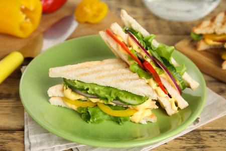 Green plate with tasty sandwiches on wooden tableの写真素材