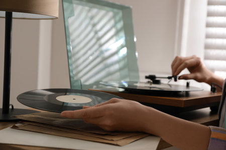 Young woman using turntable at home, closeupの写真素材