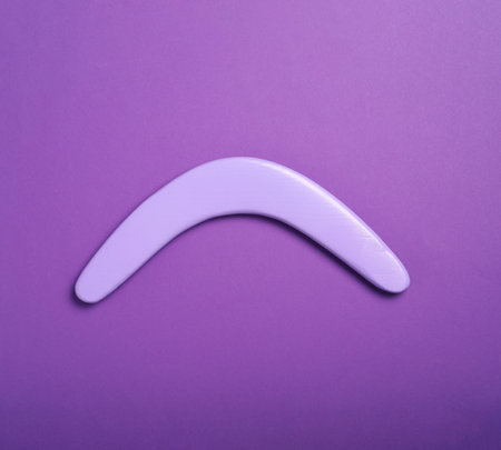 Lilac wooden boomerang on purple background, top viewの写真素材