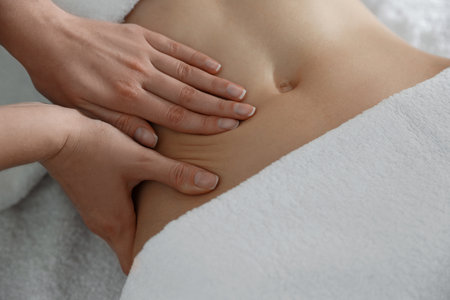 Woman professional receiving belly massage, closeup viewの写真素材