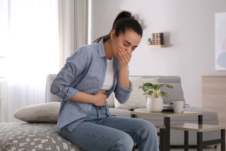 Young woman suffering from nausea at home. food poisoningの写真素材