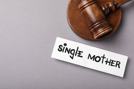 Being single mother after divorce concept. Card and judge gavel on gray background, flat layの写真素材