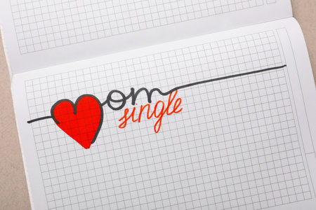 Notebook with words Single Mom on gray table, top viewの写真素材