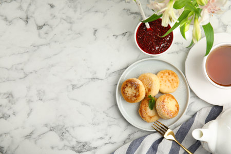 Delicious cottage cheese pancakes with icing sugar on white marble table, flat lay. Space for textの写真素材