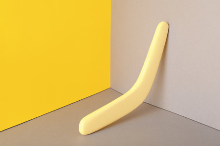 Yellow wooden boomerang on color background. outdoor activitiesの写真素材