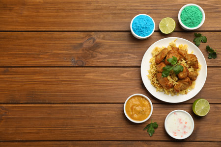 Traditional Indian food and color powders on wooden table, flat lay with space for text. Holi festival celebrationの写真素材