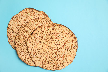 Tasty matzos on light blue background, flat lay. Passover (Pesach) celebrationの写真素材