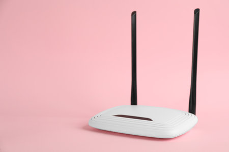 Modern WiFi router on light pink background. Space for textの写真素材