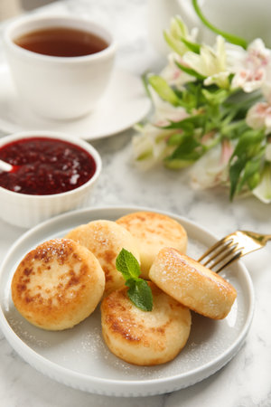Delicious cottage cheese pancakes with mint and icing sugar on white marble tableの写真素材