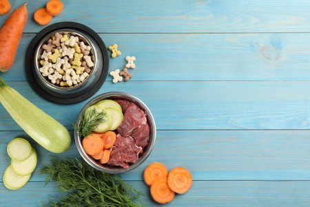 Pet food and natural ingredients on light blue wooden table, flat lay. Space for textの写真素材