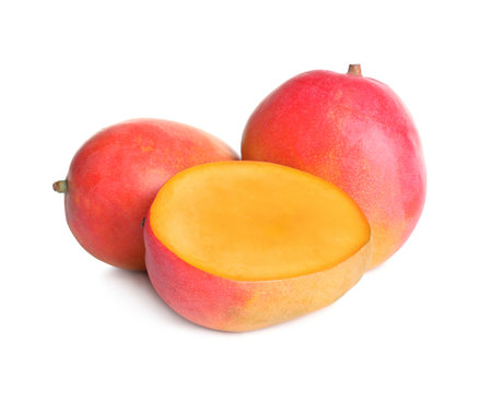 Delicious whole and cut mangoes on white backgroundの写真素材