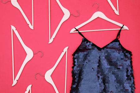 Women's garment and hangers on pink background, flat lay. clothes rent conceptの写真素材