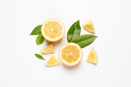 Flat lay composition with juicy lemon slices and green leaves on white backgroundの写真素材