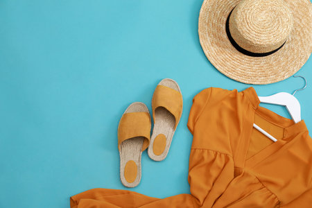 Dress, straw hat and shoes on light blue background, flat lay with space for text. clothes rent conceptの写真素材