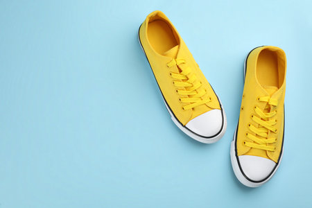 Pair of trendy sneakers on light blue background, flat lay. Space for textの写真素材