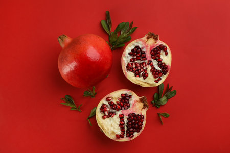 Flat lay composition with ripe pomegranates on red backgroundの写真素材