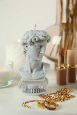 David bust candle and bijouterie on white table. Stylish decorの写真素材
