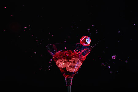 Casino dice falling into glass of alcohol drink on black backgroundの写真素材