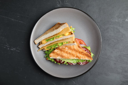 Plate with tasty sandwiches on black table, top viewの写真素材