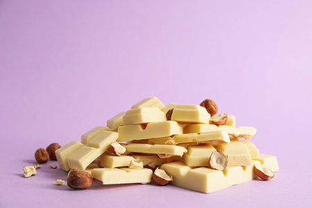 Delicious white chocolate with hazelnuts on violet backgroundの写真素材