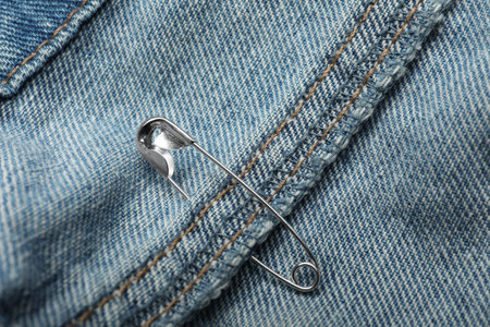 Close up view of metal safety pin on clothingの写真素材