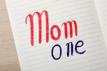 Being single mother concept. Notepad with text Mom One on white wooden table, top viewの写真素材