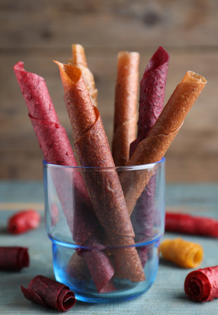 Delicious fruit leather rolls on blue wooden tableの写真素材