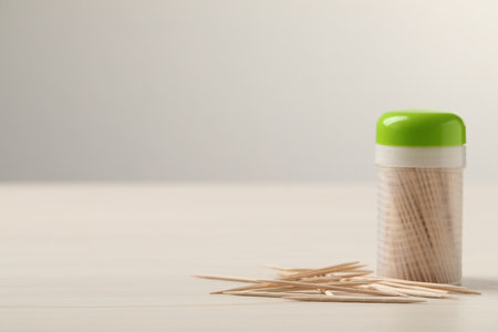 Disposable toothpicks and holder on white wooden background. Space for textの写真素材