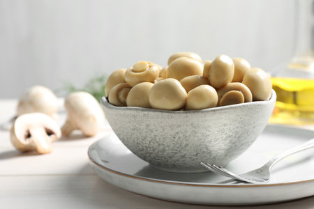 Delicious marinated mushrooms in bowl on white tableの写真素材