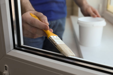 Man painting window frame at home, closeupの写真素材