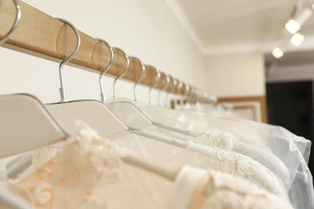 Different wedding dresses on hangers in boutique, closeupの写真素材