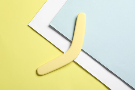 Yellow wooden boomerang on color background, top viewの写真素材