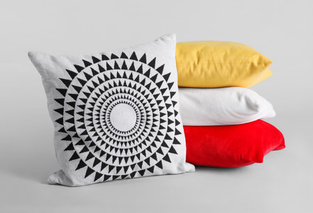 Different stylish soft pillows on gray background