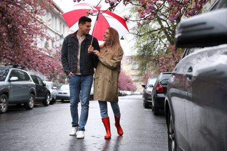 Lovely couple with umbrella walking on spring dayの写真素材