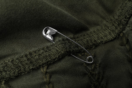 Close up view of metal safety pin on clothing
