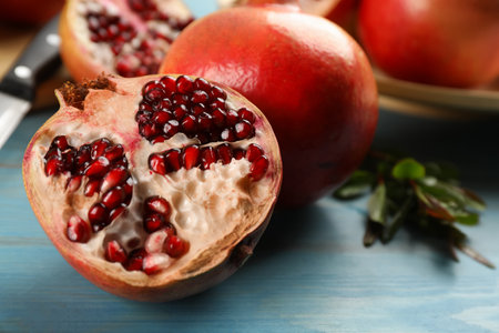 Ripe pomegranates on light blue wooden table, closeup. Space for textの写真素材