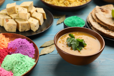 Traditional Indian food and color powders on light blue wooden table. Holi festival celebrationの写真素材