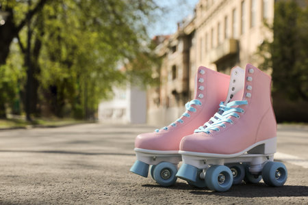 Stylish pink roller skates outdoors on sunny day. Space for textの写真素材