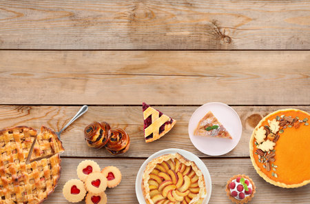 Many different delicious pies on wooden table, flat lay. Space for textの写真素材