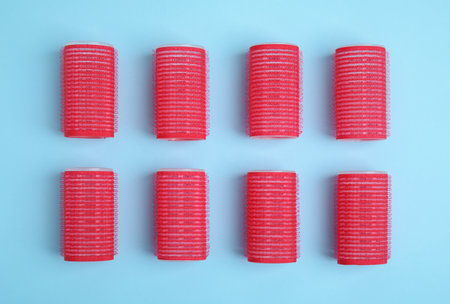 Hair curlers on turquoise background, flat lay. Styling toolの写真素材