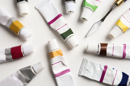 Tubes with paints and spatula on blank canvas, flat layの写真素材