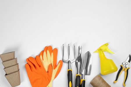 Flat lay composition with gardening tools on white background, space for textの写真素材