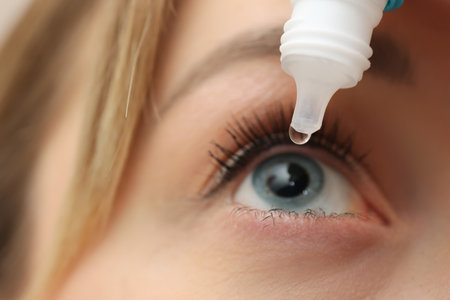 Young woman using eye drops, closeup viewの写真素材