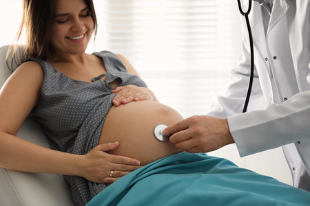 Doctor examining woman before giving child birth in maternity hospital, closeupの写真素材