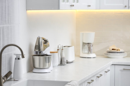 Modern toaster and other cooking appliances on countertop in kitchenの写真素材