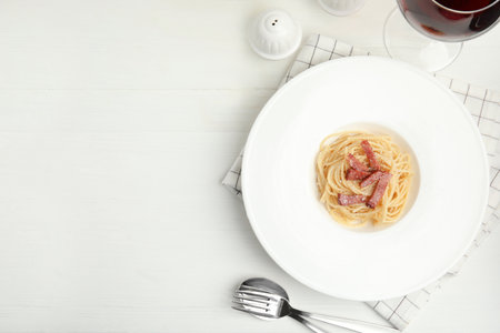 Delicious Carbonara pasta served on white wooden table, flat lay. Space for textの写真素材