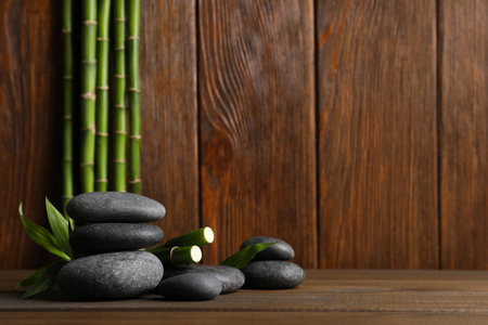 Spa stones and bamboo stems on wooden table. Space for textの写真素材