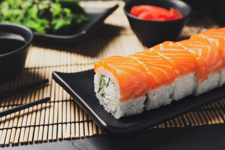Tasty sushi rolls served on black table, closeupの写真素材